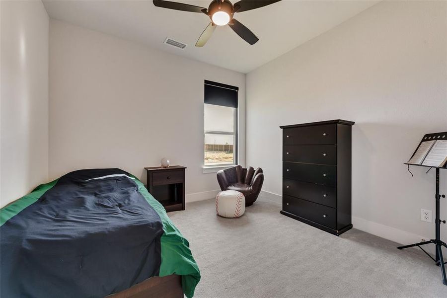 Carpeted bedroom with a ceiling fan and baseboards