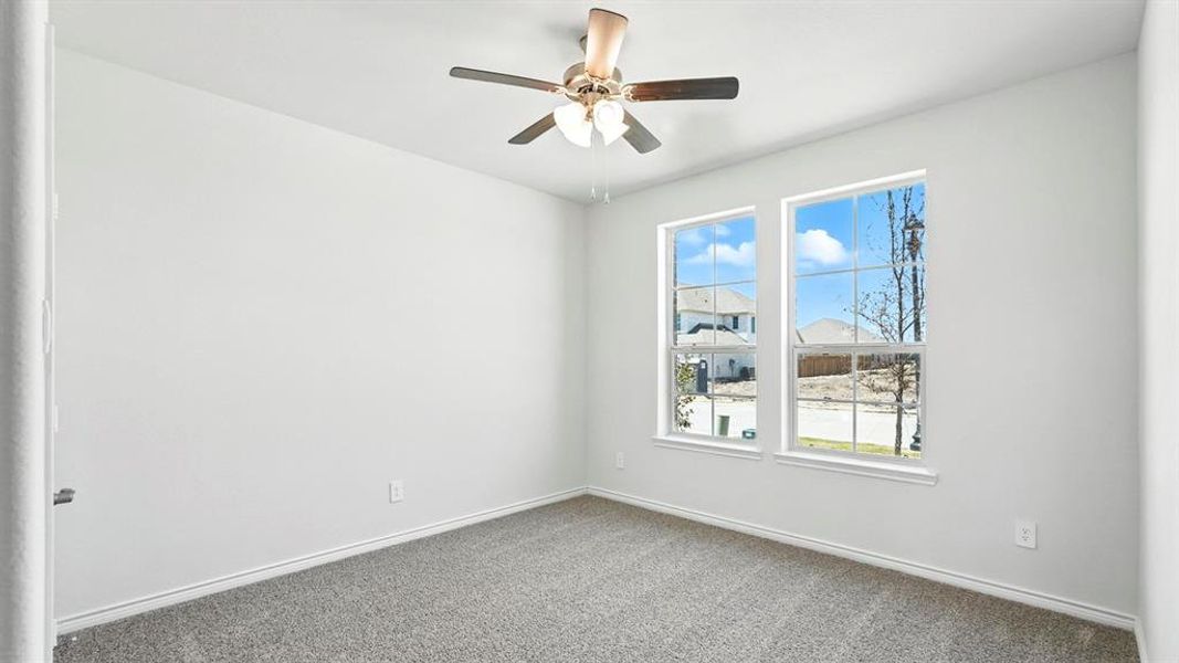 Bedroom featuring neutral carpet flooring, white walls, and a ceiling fan with light fixture