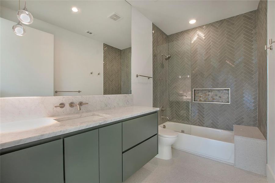 Full bathroom with vanity, tiled shower / bath combo, and toilet