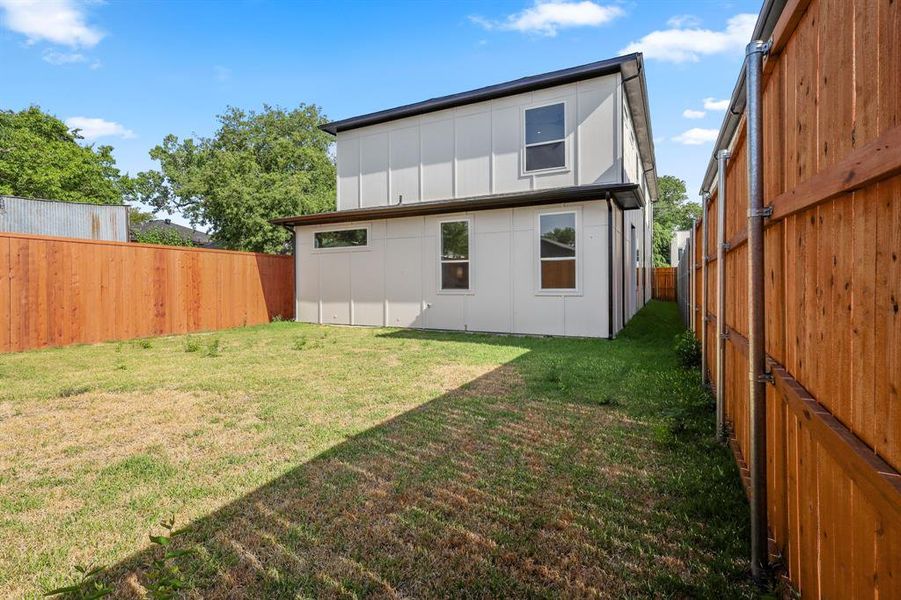 Rear view of house featuring a lawn