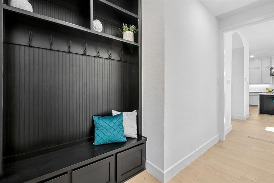 Mudroom featuring light wood-type flooring and arched walkways Mudroom featuring light wood-type flooring and arched walkways