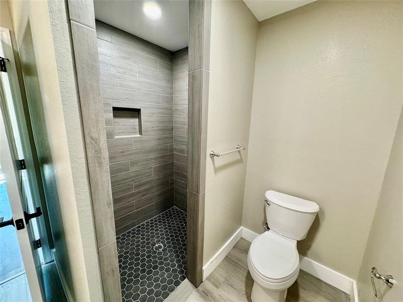 Bathroom with a shower stall and toilet