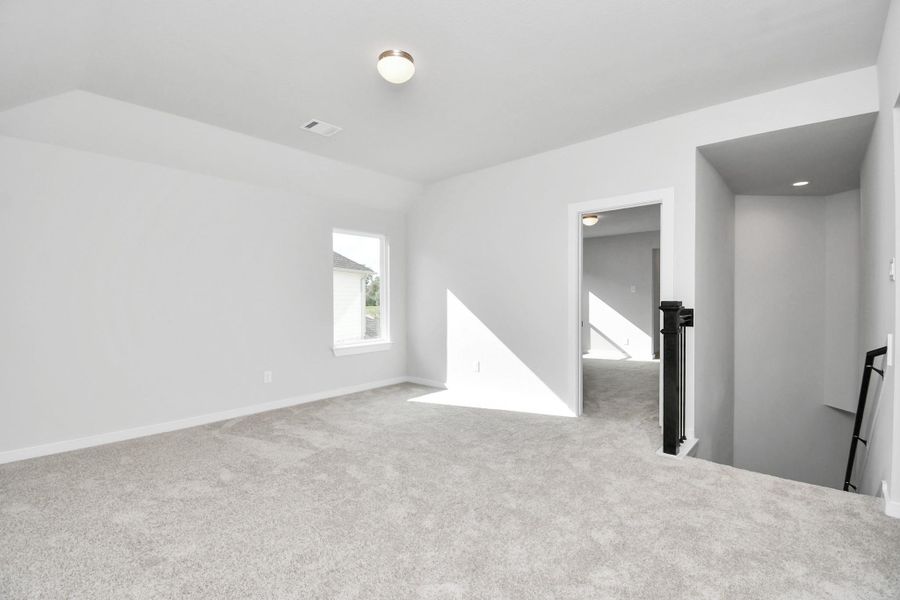Ascend to relaxation in this fantastic game room! Ideal for both casual gatherings and adult gaming, it boasts plush carpet, lofty ceilings, custom paint, and ample windows for abundant natural light. Sample photo of completed home with similar floor plan. Actual colors and selections may vary.