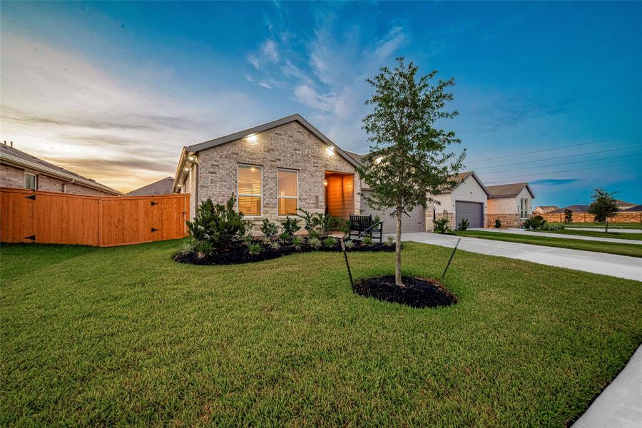 Twilight exterior view highlighting the landscaped front yard. Twilight exterior view highlighting the landscaped front yard.