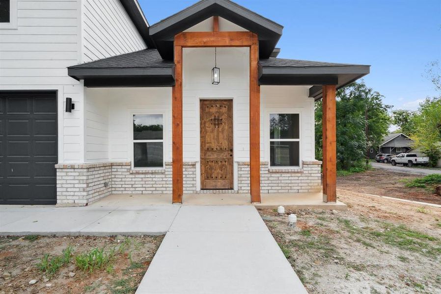 Entrance to property with a garage and a porch