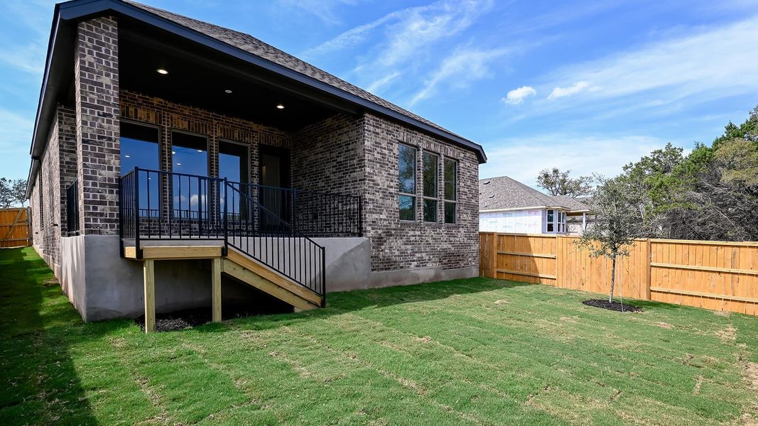 Rear view of property with brick siding and stairs
