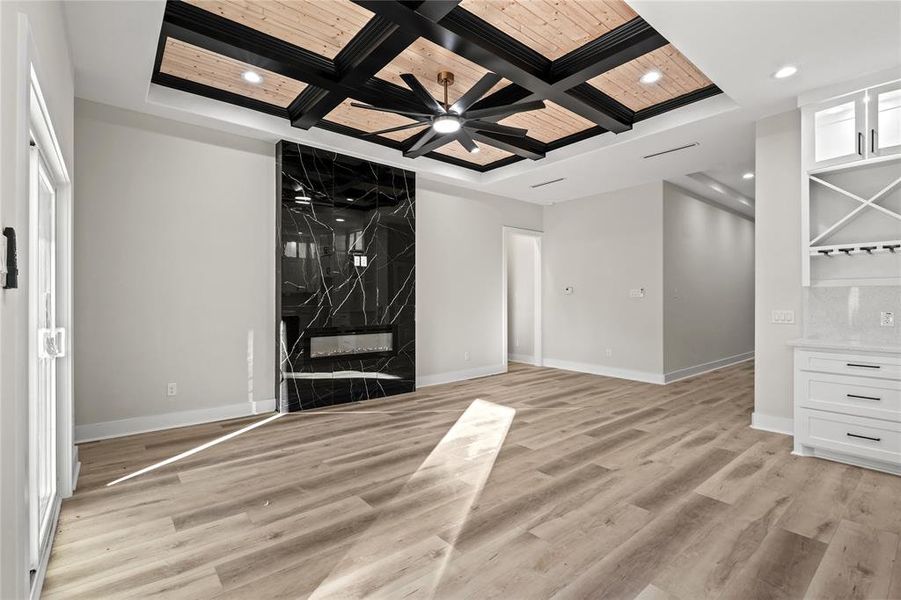 Entryway featuring light wood-type flooring, coffered ceiling, ceiling fan, beam ceiling, and wooden ceiling