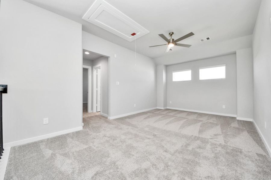 Discover a haven of leisure in this fantastic game room! Whether you're seeking a casual hangout or an adult gaming retreat, this space has it all. Enjoy the luxurious feel of plush carpet underfoot, the expansive ambiance of high ceilings, custom paint that adds a touch of personality, and windows that flood the room with refreshing natural light. Sample photo of completed home with similar floor plan. Actual colors and selections may vary.