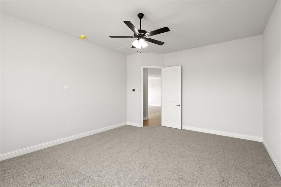 Carpeted spare room with ceiling fan