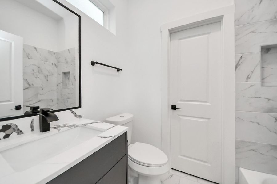 This bathroom features a modern design with marble accents, a sleek vanity with a black faucet, and a spacious shower. The neutral color palette and bright lighting create a clean, fresh atmosphere. This bathroom features a modern design with marble accents, a sleek vanity with a black faucet, and a spacious shower. The neutral color palette and bright lighting create a clean, fresh atmosphere.