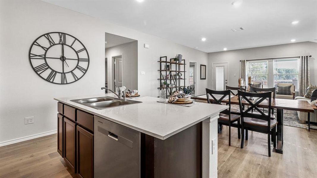 Kitchen island featuring a double basin sink and stainless steel dishwasher