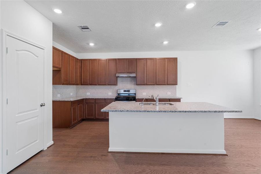 This kitchen is by far any chef’s dream! This spacious kitchen features high ceilings, stained cabinets, granite countertops, SS appliances, modern tile backsplash, recessed lighting, large kitchen island with extended countertop for breakfast bar, and a walk-in pantry all overlooking your huge family room.