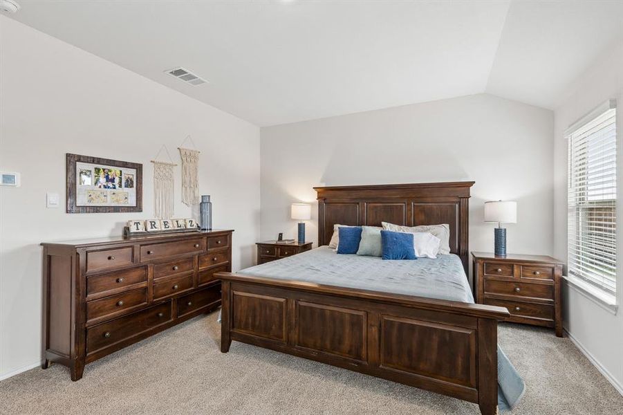 Bedroom featuring light colored carpet and vaulted ceiling Bedroom featuring light colored carpet and vaulted ceiling