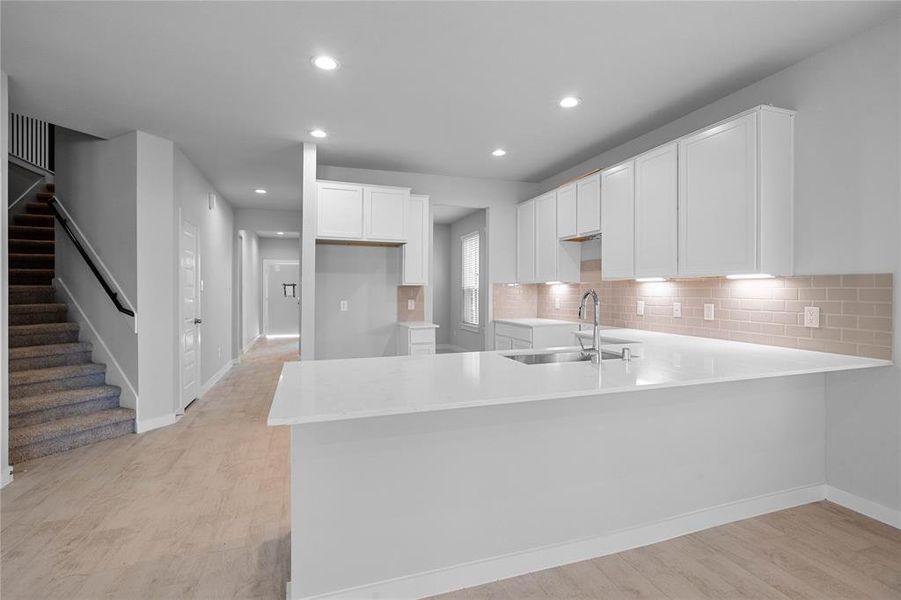 This kitchen is by far any chef’s dream! This spacious kitchen features high ceilings, white stained wood cabinets, quartz countertops, SS appliances, modern tile backsplash, recessed lighting, extended counter space for breakfast bar, and a walk-in pantry all overlooking your huge family room.