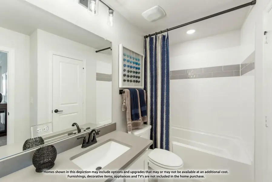 Bathroom with gray countertop vanity, large mirror, and tub-shower combo with blue curtain and white tile walls. Bathroom with gray countertop vanity, large mirror, and tub-shower combo with blue curtain and white tile walls.