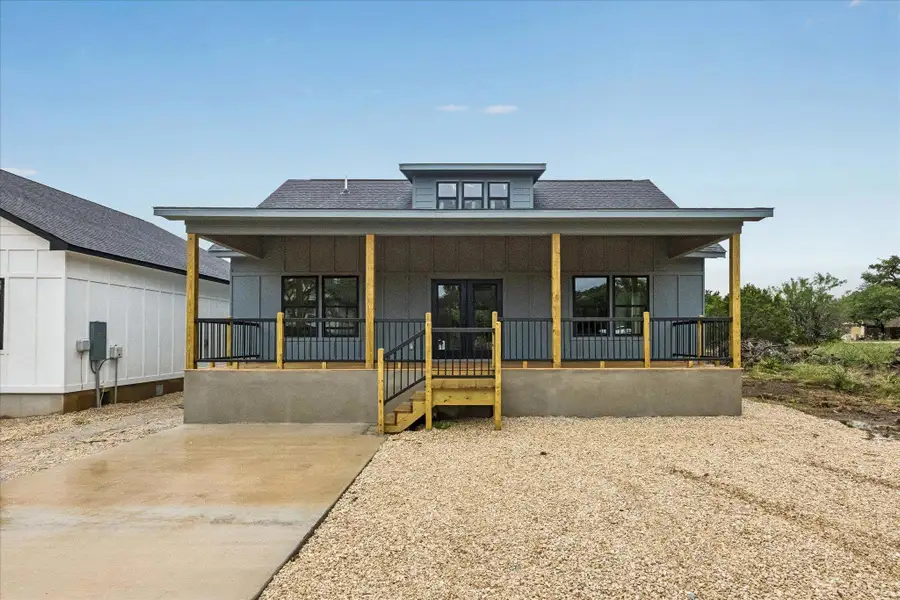 A newly constructed residence showcases a welcoming front porch with wood posts and dark railings. A newly constructed residence showcases a welcoming front porch with wood posts and dark railings.