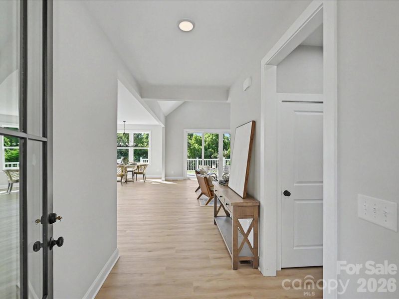 Bright and welcoming entryway opens into an airy open-concept living space featuring soaring ceilings, abundant natural light, and seamless indoor-outdoor flow.
