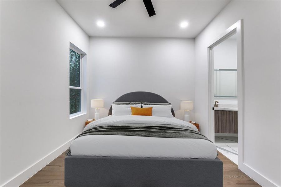Bedroom with ensuite bath, recessed lighting, ceiling fan, and wood finished floors
