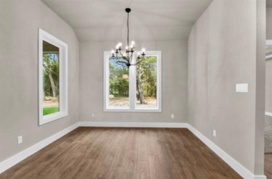 Unfurnished dining area featuring dark wood-type flooring and a chandelier