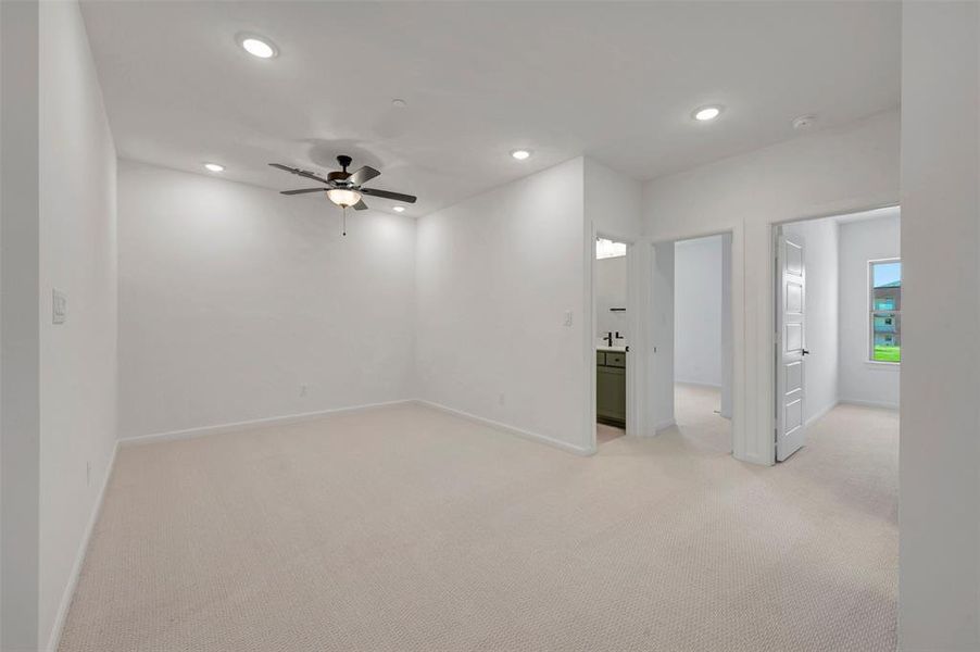 Spacious room featuring neutral carpet flooring, recessed lighting, and a ceiling fan Spacious room featuring neutral carpet flooring, recessed lighting, and a ceiling fan
