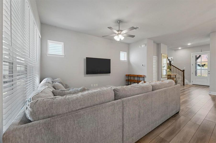 Living room with wood finished floors, stairs, ceiling fan, and recessed lighting Living room with wood finished floors, stairs, ceiling fan, and recessed lighting