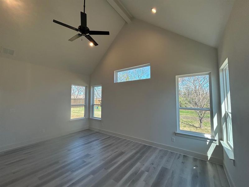 Primary bedroom with vaulted ceilings and abundance of windows