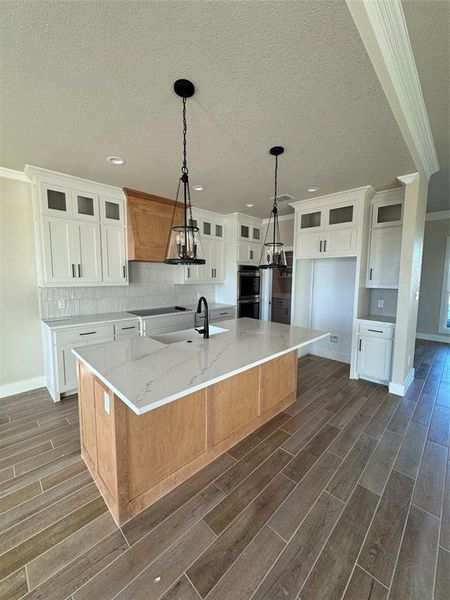 Kitchen with a large island, dark hardwood / wood-style floors, and white cabinetry