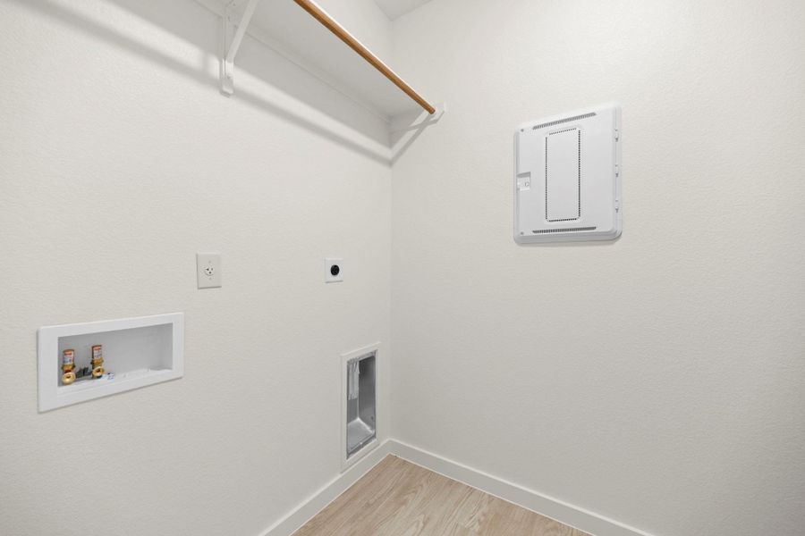 A well-appointed utility room features durable flooring and convenient laundry hookups.