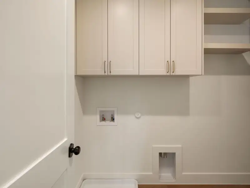 Functional utility space with ample cabinetry and essential hookups for laundry needs.