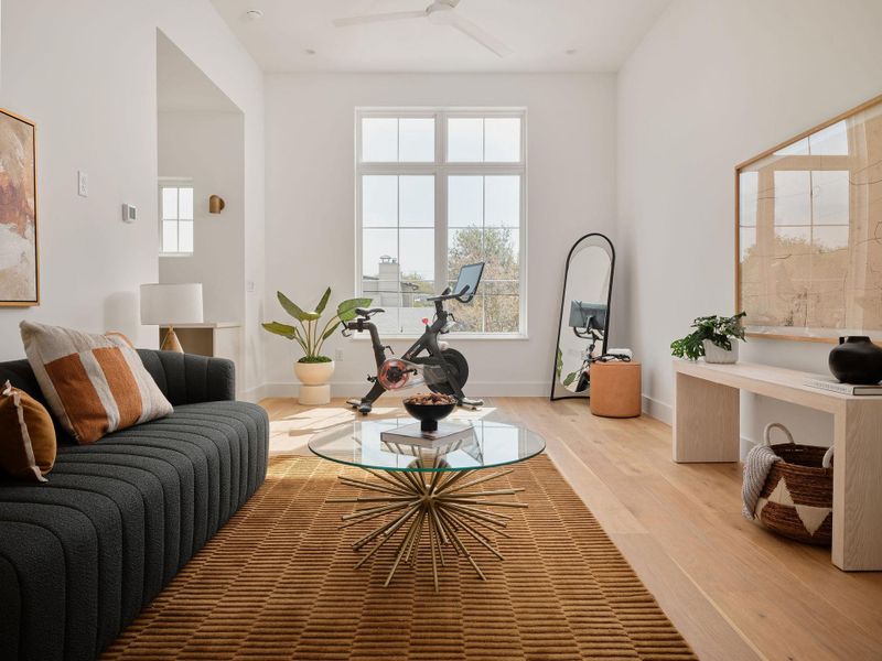 Living room featuring wood finished floors and a ceiling fan Living room featuring wood finished floors and a ceiling fan