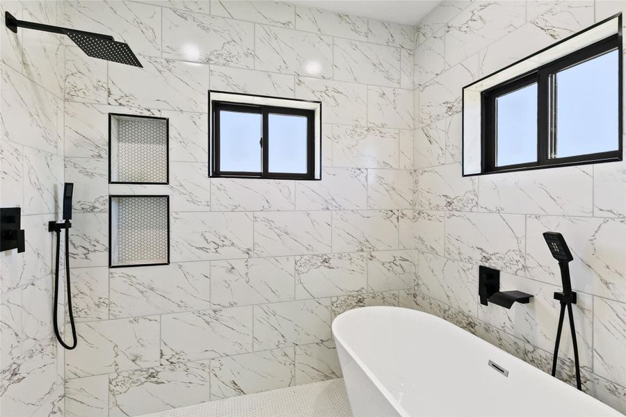 A stunning wet room serves as the centerpiece of the primary bath, combining a freestanding soaking tub and dual-head shower within a beautifully tiled space.