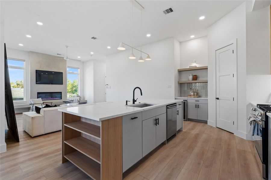 The oversized island serves as the organizational core of the main level, aligning prep space, storage, and sightlines while maintaining uninterrupted connection to the surrounding living areas.