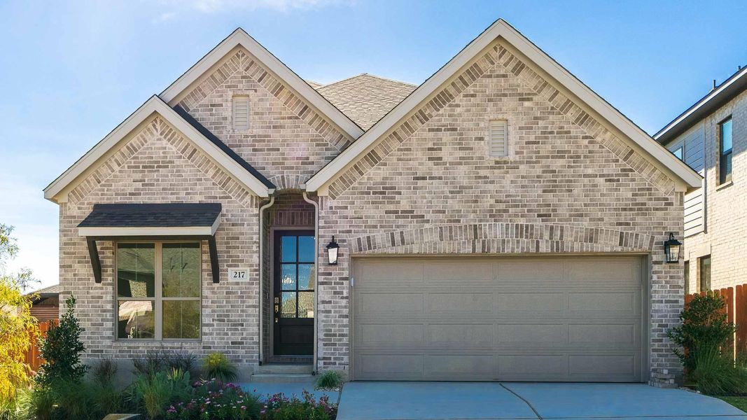 French country style house with concrete driveway, a garage, a shingled roof, and brick siding French country style house with concrete driveway, a garage, a shingled roof, and brick siding