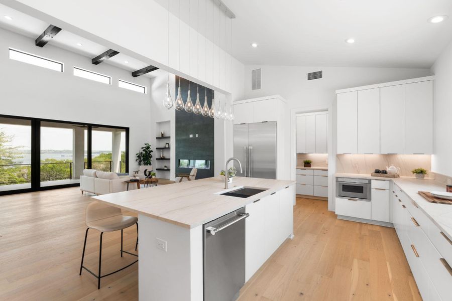 A pristine open-concept kitchen and living area flows effortlessly to a scenic outdoor vista.