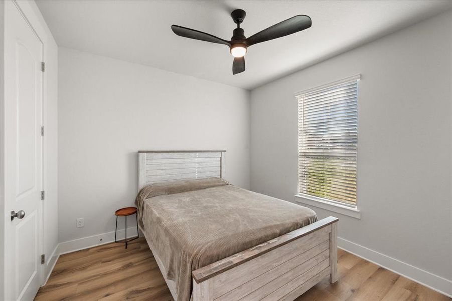 Bedroom with light wood finished floors and a ceiling fan