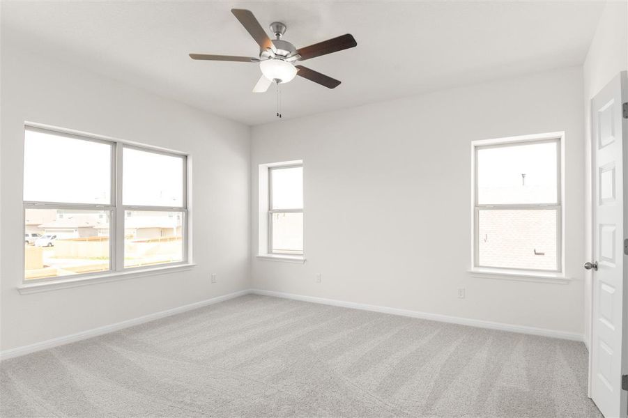 Carpeted empty room with a ceiling fan and baseboards