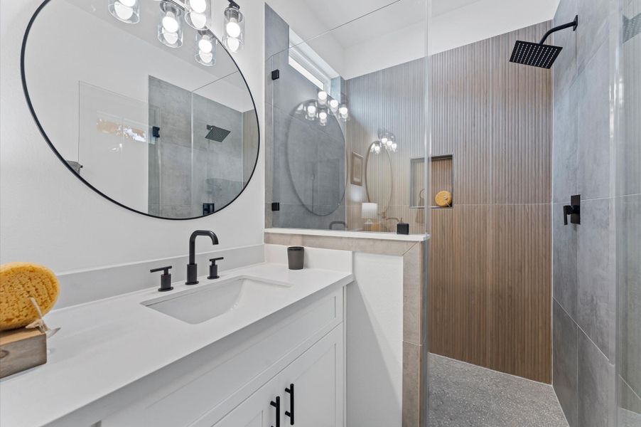 This luxurious primary bathroom blends modern elegance with spa-like comfort, featuring a spacious layout and contemporary selections throughout. A sleek double vanity with minimalist cabinetry and quartz countertops offers ample storage and style, while the glass-enclosed shower includes a built-in bench for added relaxation and convenience. This luxurious primary bathroom blends modern elegance with spa-like comfort, featuring a spacious layout and contemporary selections throughout. A sleek double vanity with minimalist cabinetry and quartz countertops offers ample storage and style, while the glass-enclosed shower includes a built-in bench for added relaxation and convenience.