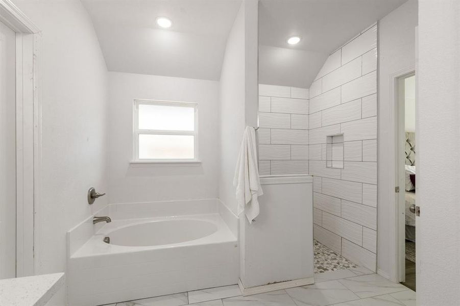 Bathroom with plus walk in shower, tile patterned flooring, and lofted ceiling