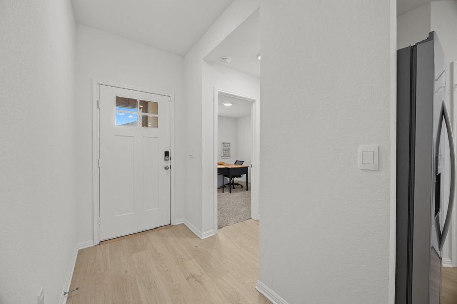 Foyer entrance featuring light wood finished floors and baseboards