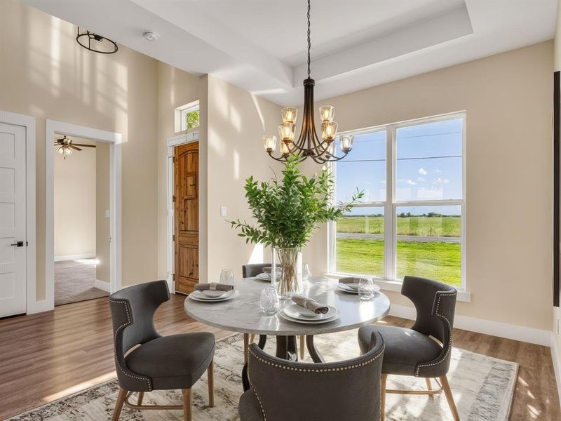 Staged Dining area featuring wood finished floors, a chandelier, and a water view Staged Dining area featuring wood finished floors, a chandelier, and a water view