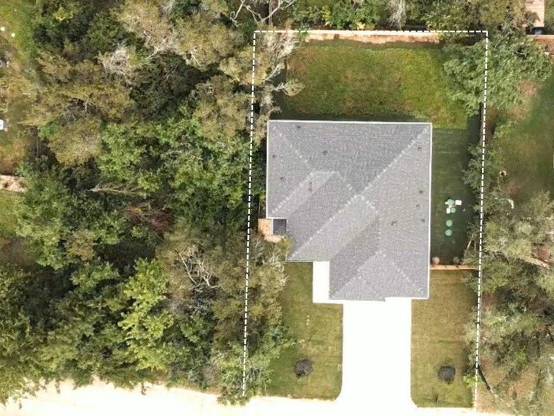 An aerial view showcases a residential property nestled amidst lush greenery with a neatly maintained lawn. An aerial view showcases a residential property nestled amidst lush greenery with a neatly maintained lawn.