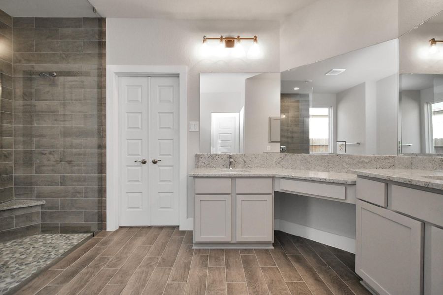 Full length mirrors, double sinks, modern vanity lights, and sleek hardware make this primary bathroom a sophisticated oasis of contemporary elegance and functionality. Sample photo of completed home with similar plan. As built color and selections will vary. Full length mirrors, double sinks, modern vanity lights, and sleek hardware make this primary bathroom a sophisticated oasis of contemporary elegance and functionality. Sample photo of completed home with similar plan. As built color and selections will vary.