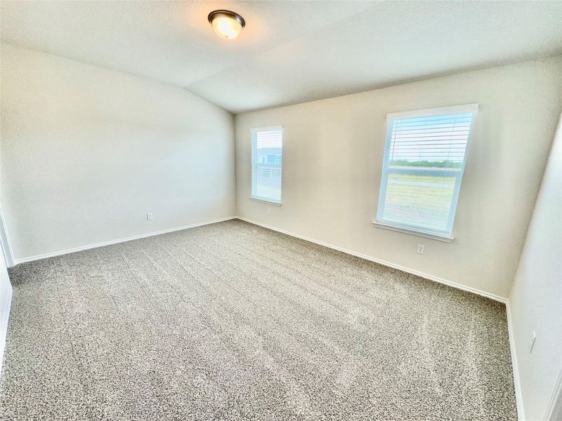 Spare room with carpet floors and vaulted ceiling