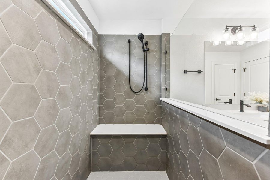 Modern hexagon tile details create a chic and functional walk-in shower with a built-in bench.