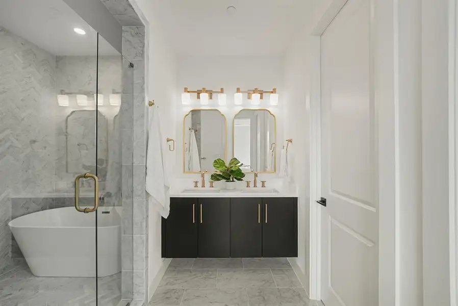 Modern bathroom featuring a floating dual-sink vanity with a light countertop and gold-finish fixtures Modern bathroom featuring a floating dual-sink vanity with a light countertop and gold-finish fixtures