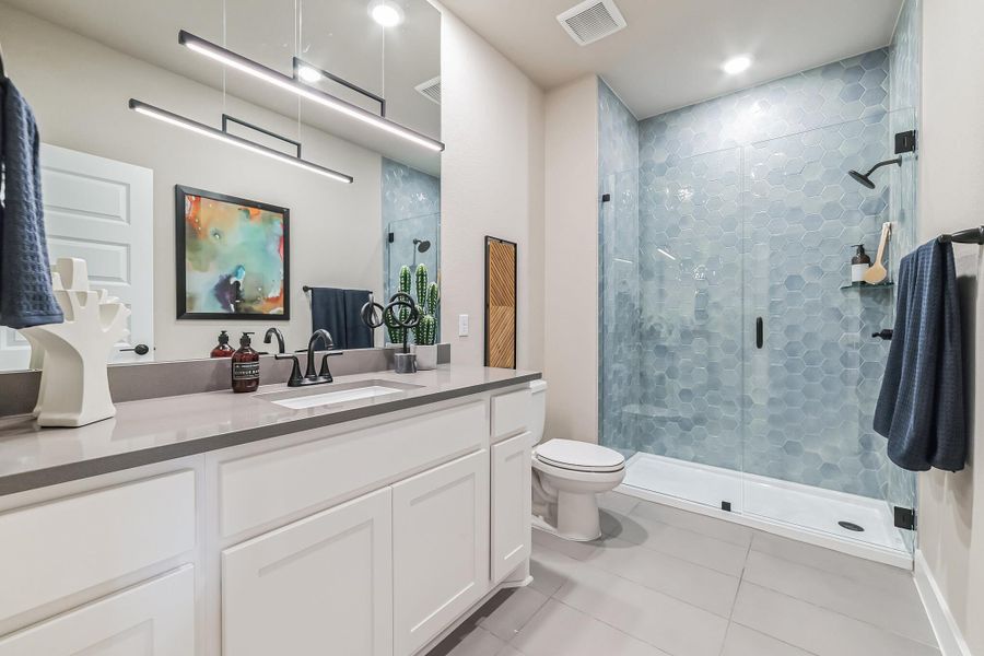 Bathroom with vanity, a shower stall, and light tile patterned flooring