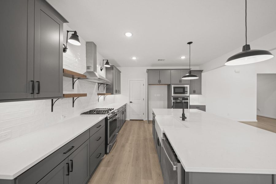 Stylish kitchen with grey cabinets and quartz counters (*Photo not of actual home and used for illustration purposes only.)