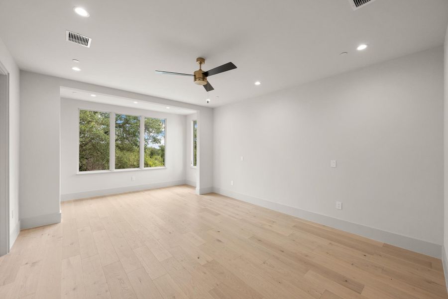 Well-lit living area with hardwood floors and abundant natural light from multiple windows. Well-lit living area with hardwood floors and abundant natural light from multiple windows.