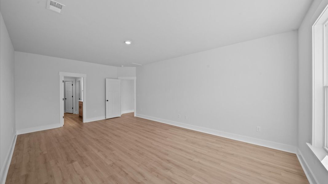 Accomplished primary retreat with eye-catching hardwood flooring in a desirable community