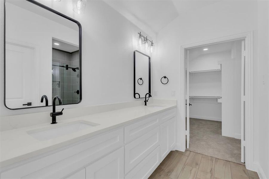 Bathroom with a walk-in shower, double vanity, a his & hers closet, wood tiled floors, and recessed lighting